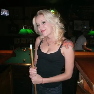 a woman posing with a pool stick