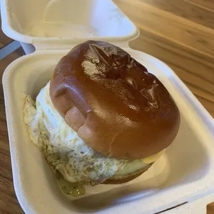 a half eaten sandwich in a styrofoam container