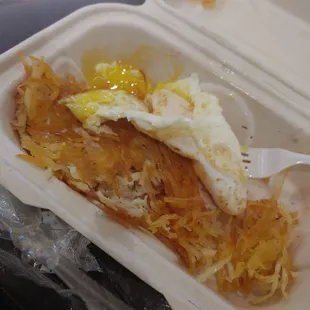 an egg and hash browns in a styrofoam container