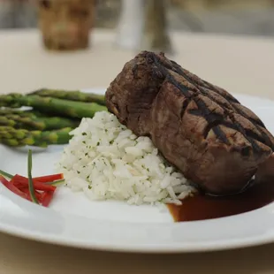 a plate of food with rice and asparagus