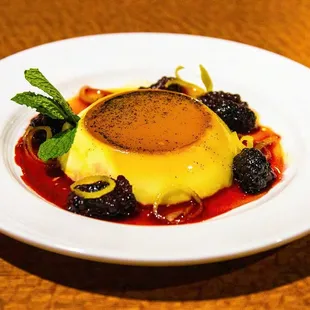 Vanilla custard topped with caramel and served with sweetened blackberries and candied lemon peel.