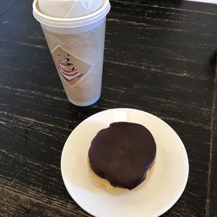 a cup of coffee and a donut on a plate