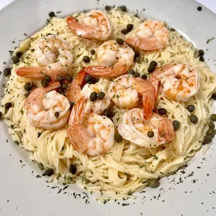 a plate of pasta with shrimp and capers