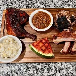 a variety of meats and sides on a cutting board