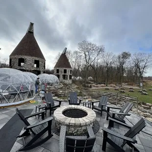 a patio with chairs and a fire pit