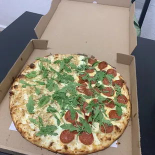 White sauce with half chicken and half pep with fresh arugula on top