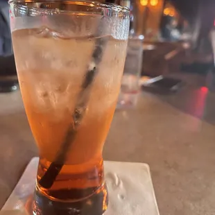 a man sitting at a bar with a drink in front of him