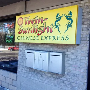 Sign out front and neon sign advertising their Pho.