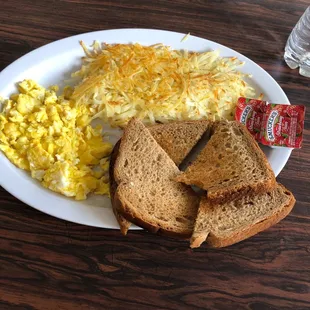 a plate of eggs, toast, and hash browns