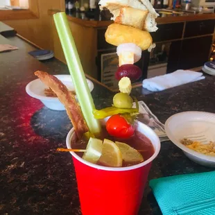 a bloody drink with bacon, tomatoes, celery, and bread