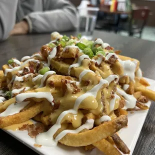 a plate of fries with cheese and bacon