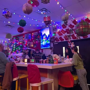 people sitting at a bar with christmas decorations