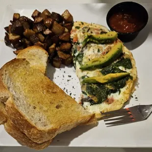 Egg white spinach omelette with avocado, potatoes, sour dough toast, and salsa