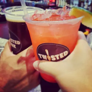 two people holding drinks at a bar