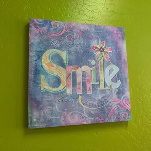 the word smile painted on a wall