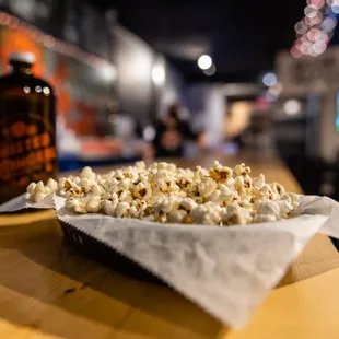 a bowl of popcorn and a bottle of beer