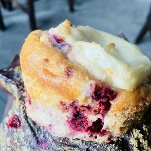a hand holding a muffin with a bite taken out of it