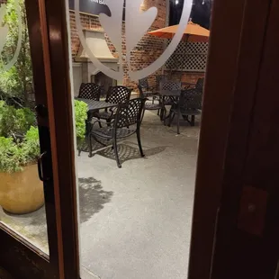 Looking out from waiting area to cute little gas fireplace and outdoor dining area on patio.