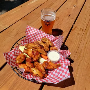 a basket of chicken wings and a pint of beer