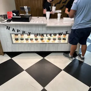 a man and a woman standing at a candy shop counter