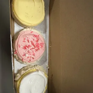four different flavors of frosting in a box