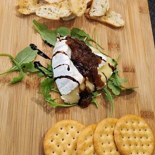 cheese, crackers, and crackers on a cutting board