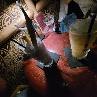 a woman sitting at a table with a drink