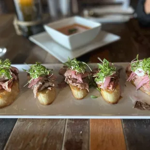 Chilled Flank Steak, pickled red onion, and chimichurri crema, served on crostini.