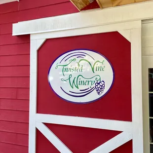 a red barn with a sign for twisted vine winery