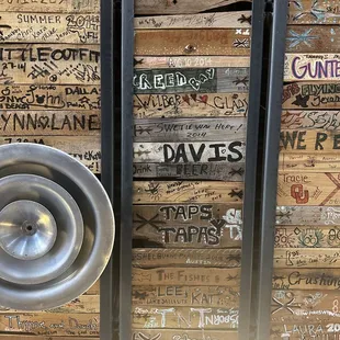 a metal urinal in front of a stack of wooden crates