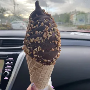 a hand holding a cone of ice cream