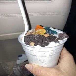 a hand holding a cup of ice cream