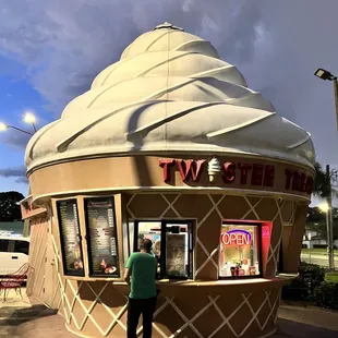 a man standing in front of a giant ice cream cone