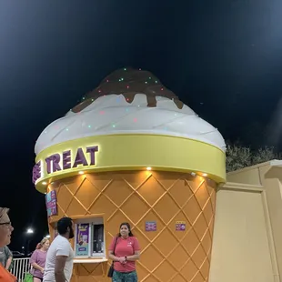 a woman standing in front of an ice cream cone