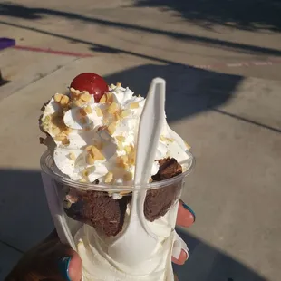 Brownie sundae with whipped cream, peanuts, and a cherry on top