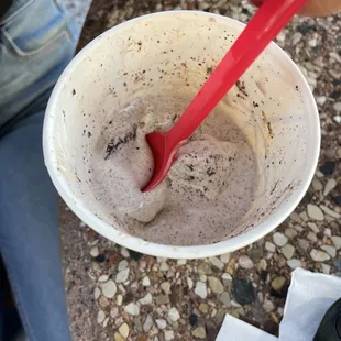 a red spoon sticking out of a cup of ice cream