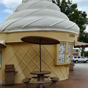 an ice cream cone with a table and umbrella