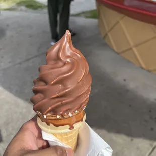 a hand holding an ice cream cone