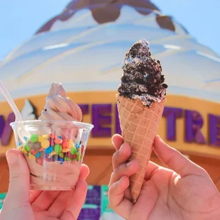 two people holding ice cream cones