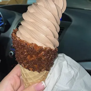 a hand holding an ice cream cone