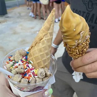 a person holding an ice cream cone with sprinkles and sprinkles