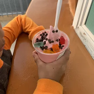 a child holding a bowl of ice cream