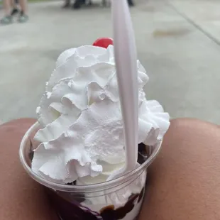 Hot fudge sundae with whipped cream, cherry, (missing the nuts).