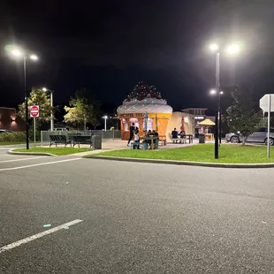 people sitting at tables in a park at night