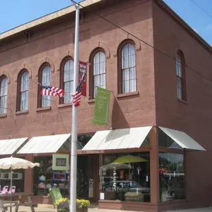 a brick building with awnings and tables outside
