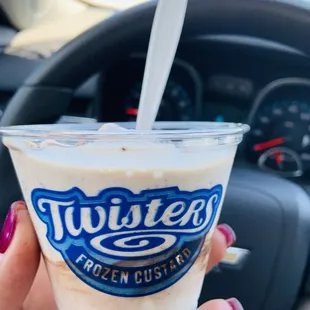 a hand holding a cup of frozen custard