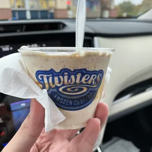 a hand holding a cup of ice cream