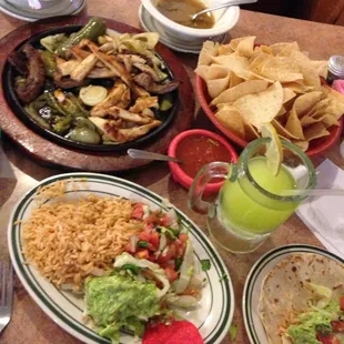 Sizzling fajitas plate with a melon margarita.