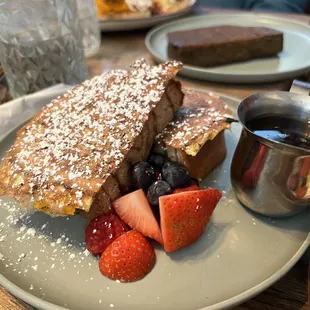 a plate of french toast with strawberries and blueberries