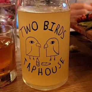 Beer in glass with Two Birds Taphouse logo.